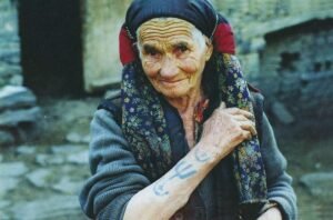 Хамис Мамиева из села Ицари, 87 лет. Одета в традиционный даргинский платок чухта и показывает руку с татуировками. Фото: Габиб Исмаилов